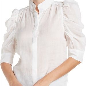 This chic button down blouse with a sheer puffed sleeve. 24" length.